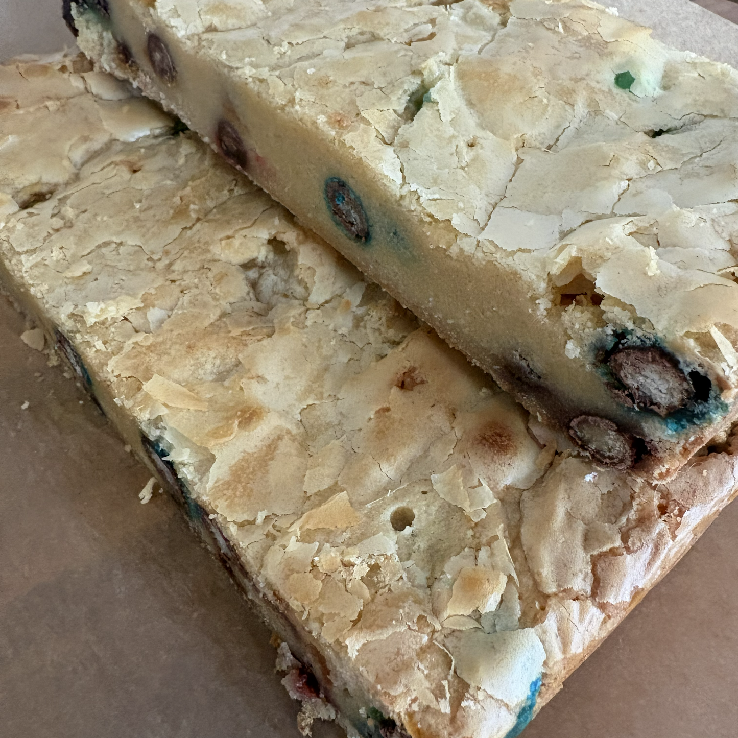 Two pieces of cookie dough on a brown surface
