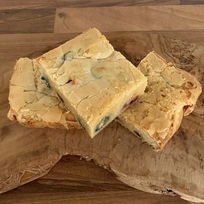 Three pieces of blondie on a wooden cutting board