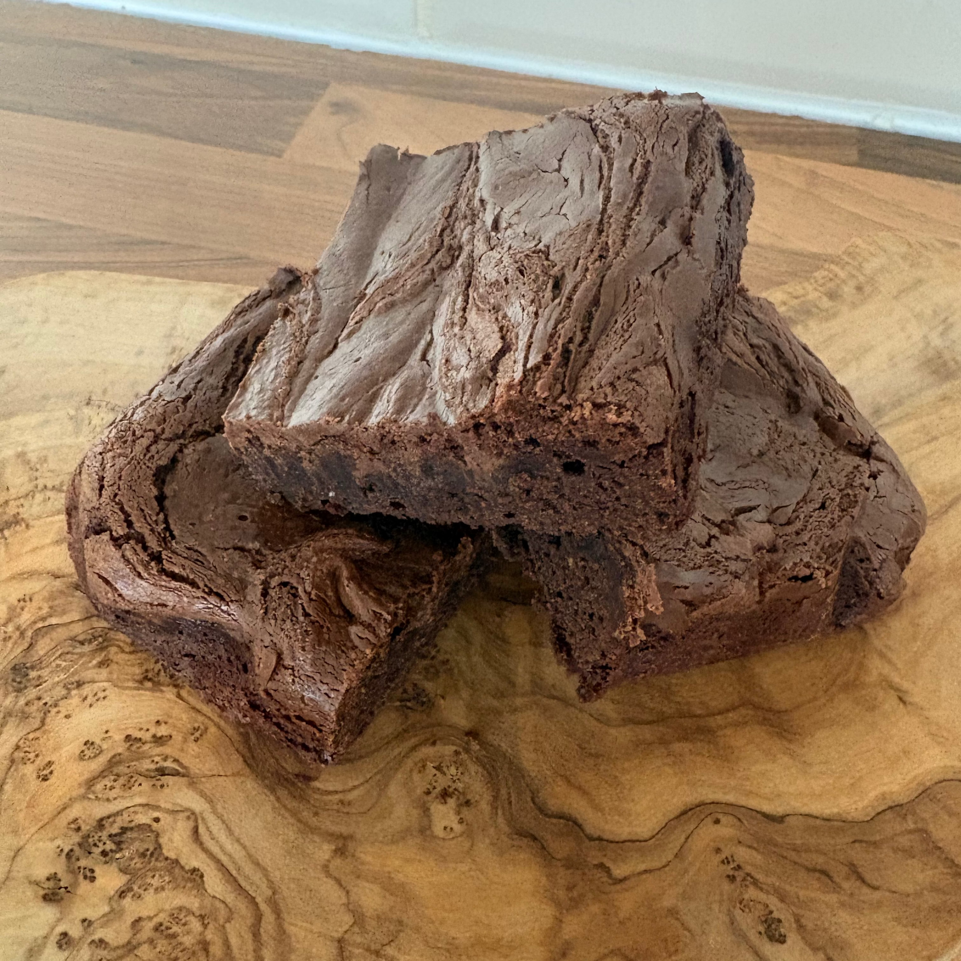 Two Nutella chocolate brownies on a wooden surface